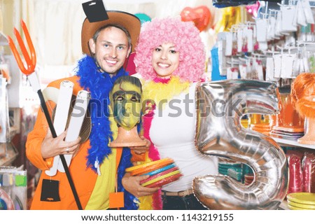 Woman and man are preparing for fest and choosing festive accessories. 