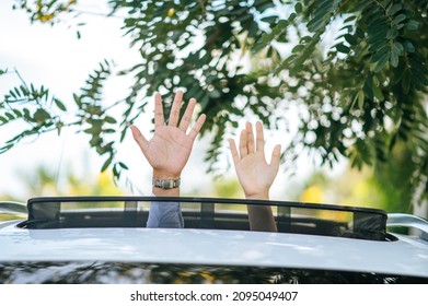 Woman And Man Putting His Hands Out Of The Car Sunroof Top