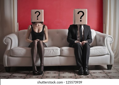 A woman and a man sitting on a sofa with a box on which is drawn a question mark over their heads - Powered by Shutterstock