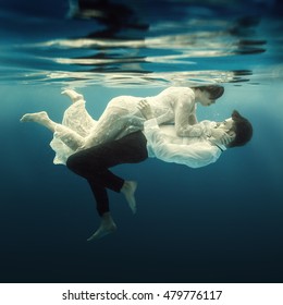 Woman And Man Swimming Underwater