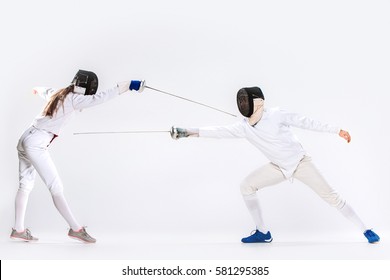 The woman and man wearing fencing suit practicing with sword against gray - Powered by Shutterstock