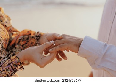 Woman and man wearing wedding rings at the beach
