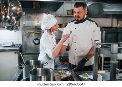 Woman And Man Woking Together. Professional Chef Preparing Food In The Kitchen.