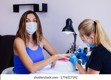 Woman And Manicure Master In Protective Medical Mask In Beauty Salon.. Manicure Procedure, Nail Care Grand Opening! Quarantine Is Over. Small Businessess Are Open Again.
