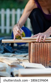 Woman Marking A Line Where To Cut A Wooden Plank In A Diy Project Of Home Renovation And Improvement.