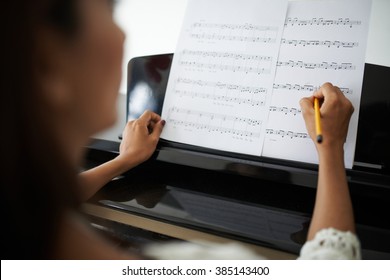 Woman marking up in music sheet before playing - Powered by Shutterstock