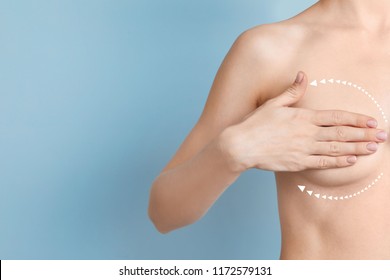 Woman with marks on breast and space for text against color background. Cosmetic surgery