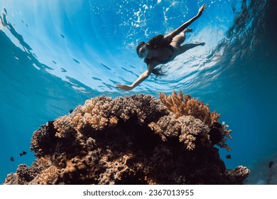 Woman with mask dive to the deep near corals in tropical blue ocean. Snorkeling with woman in Hawaii - Powered by Shutterstock