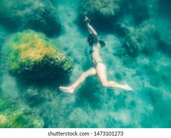 woman with mask and flipper underwater discovering sea bottom. summer vacation. top view