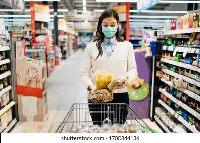 Woman With Mask Safely Shopping For Groceries Amid The Coronavirus Pandemic In A Stocked Grocery Store.COVID-19 Food Buying In Supermarket.Panic Buying,stockpiling.Food Shortage.Lockdown Preparation.