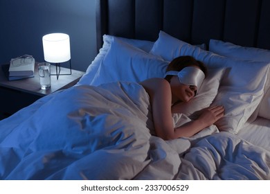 Woman with mask sleeping in bed at night