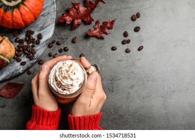 Woman With Mason Jar Of Tasty Pumpkin Spice Latte At Grey Table, Top View. Space For Text