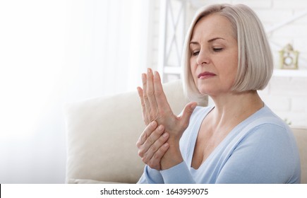 Woman Massaging Her Arthritic Hand And Wrist Closeup