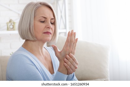 Woman Massaging Her Arthritic Hand And Wrist Closeup