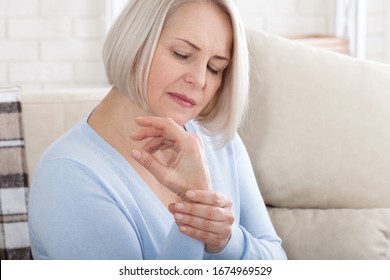 Woman Massaging Her Arthritic Hand And Wrist Closeup