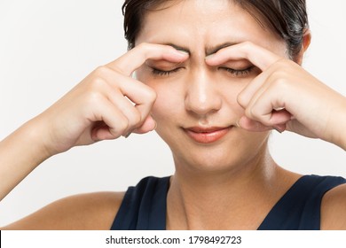 A woman is massaging her eyes.