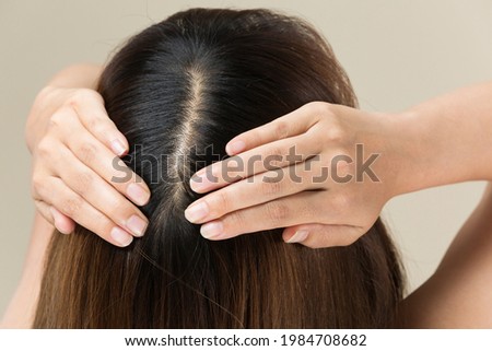 A woman is massaging her scalp.