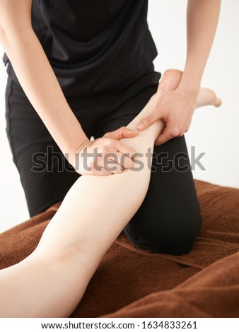 A woman massaging her thighs in a bright aesthetic salon