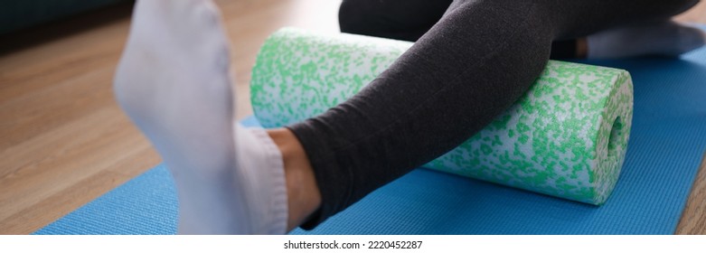 Woman Massaging Leg With Foam Roller Closeup