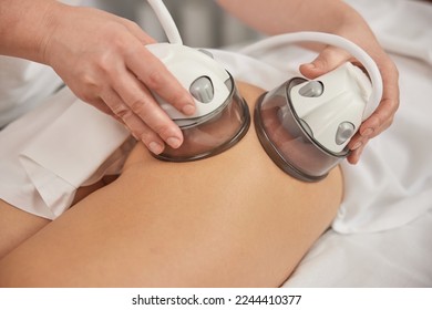 woman masseur, massage procedure, Applying vacuum. In clinic, vacuum body massage, problems areas slimming, suitable equipment for body care professional, lpg massage procedure, anti-cellulite - Shutterstock ID 2244410377