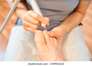 Woman Master Pedicures A Man. Hardware Pedicure. Leg Close Up. A Man Sits In A Pedicure Chair