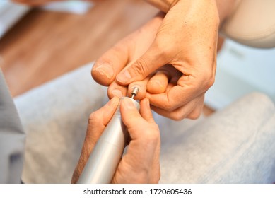 Woman Master Pedicures A Man. Hardware Pedicure. Leg Close Up. A Man Sits In A Pedicure Chair