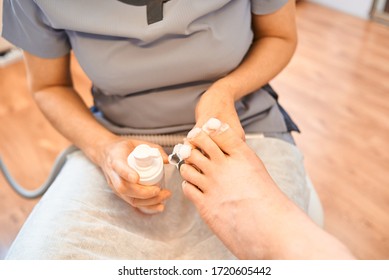 Woman Master Pedicures A Man. Hardware Pedicure. Leg Close Up. A Man Sits In A Pedicure Chair