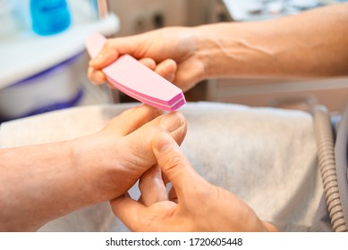 Woman Master Pedicures A Man. Hardware Pedicure. Leg Close Up. A Man Sits In A Pedicure Chair