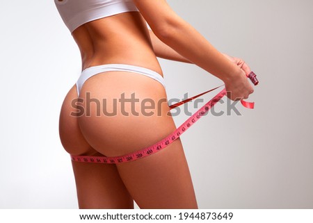 Woman measures her buttocks, losing weight	
