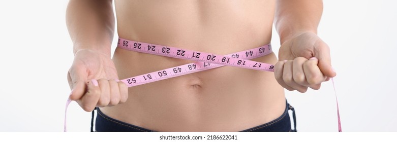 A Woman Measures Her Waist With A Tape, Close-up, Blurry. The Concept Of Weight Loss Marathon, Keto Diet, Paleo