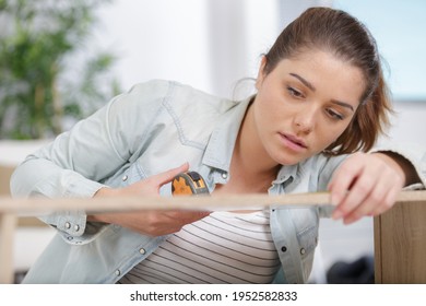 A Woman Measuring A Furniture