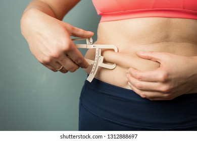 Woman Measuring Her Body Skin Fat With Fat Caliper