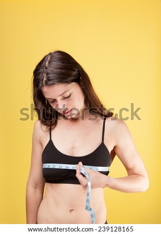 woman measuring her bust size with a black sport bra