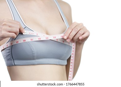 Woman measuring her chest for breast implant surgery.