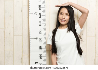 A Woman Measuring Her Height.