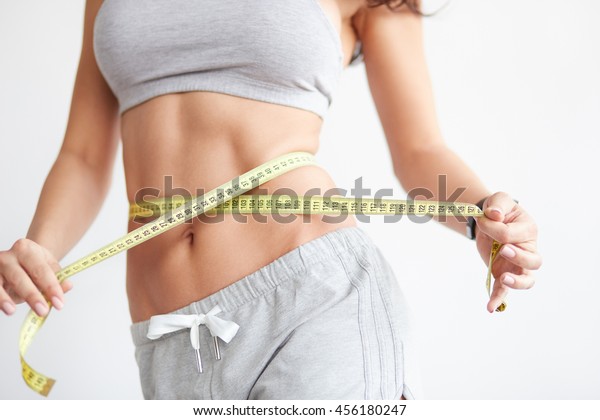 ウエストラインを測る女性 完璧なスリムな体と胴体を持つ女性の接写 健康的な栄養と体重減少のコンセプト の写真素材 今すぐ編集