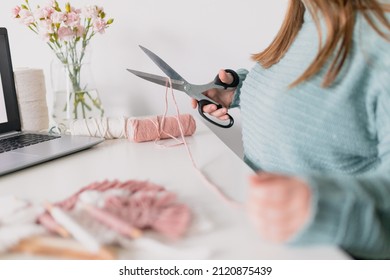 Woman Measuring Piece Of The Rope From The Coil For Macrame Weaving With Big Scissors. Handmade Macrame Belt In Work Process. Female Hobby. Wall Hanging Decor. Diy