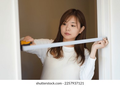 A woman measuring the room
 - Shutterstock ID 2257937121