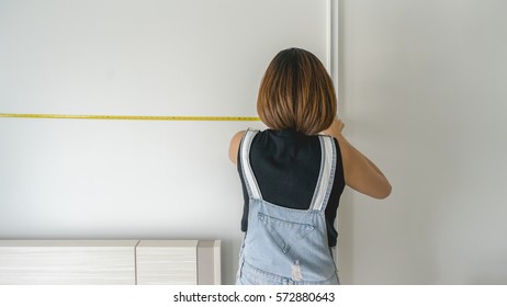 A woman measuring size of the room - Powered by Shutterstock