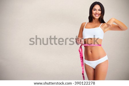 Woman with measuring tape over gray background.