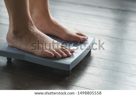 Woman measuring weight on weight scale have a copy space for text.