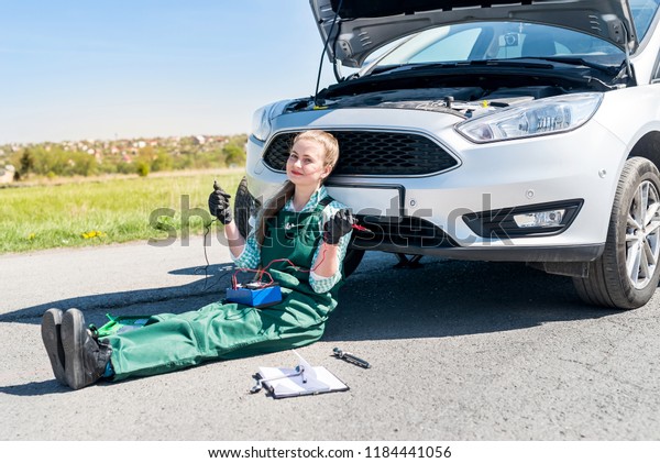 Woman\
mechanic searching problems with car\
engine