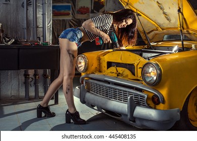 Woman Mechanic In Sexy Shirts Is Repairing An Old Car With The Screwdriver.