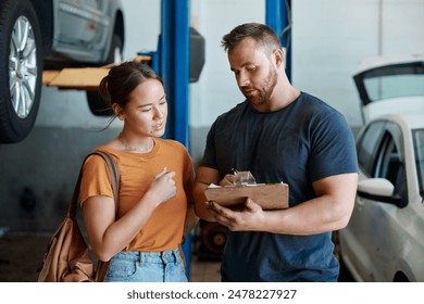 Woman, mechanic and sign quote in auto repair shop, invoice and service for car maintenance bill. Female person, clipboard and customer for vehicle paperwork, contract and talking in garage workshop - Powered by Shutterstock