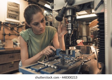 woman mechanic is using a vertical electric dill machine - Powered by Shutterstock