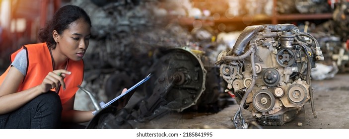 Woman Mechanic Worker Working At Old Motor Automotive Spare Parts Warehouse. Woman Warehouse Worker Checking Old Engine, Motor, Machine At The Garage Industry Factory