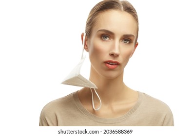 Woman With Medical Face Mask Hanging On Her Ear Isolated Over White Background Looking At Camera