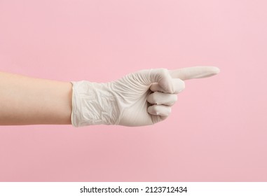 Woman In Medical Glove Pointing At Something On Pink Background