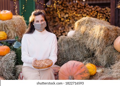 Woman In Medical Mask Celebrates Thanksgiving 2020. Tradition Cake Decoration. Coronavirus Protection Social Distance Loneliness. Face Cover Pandemic Homemade. Hello, Autumn Quarantine