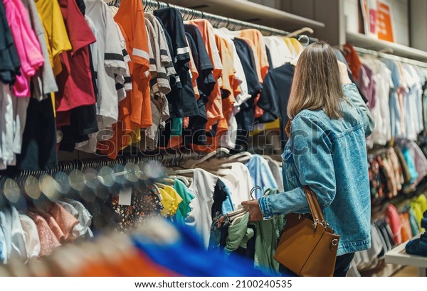 Woman\
in medical mask choosing clothes in outlet\
store.